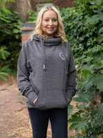 Model outdoors in nature wears womens Cowl Neck Hoodie - Dark Grey hoodie with silver metallic love heart motif. Charcoal ladies hoodie with Long sleeves and thumb loops to cuffs. Front kangaroo pouch pocket. Cross neck sweatshirt with hood