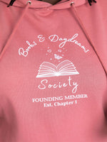 Dusty Rose pink ladies slogan hoodie with book lover design featuring a white “Books & Daydreams Society – Founding Member, Est. Chapter 1” and an open book and whimsical stars. The best bookish gift for her. Sweatshirt with hood, comfy casual top for cosy reading days. Unisex fit casual hoody perfect for autumn sweater weather. Drawstrings and kangaroo pocket.