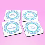 Wellbeing gift. Four square wooden backed personal affirmations coaster set. Theme is Letting Go in this set of four. Mandala design with daily affirmation wording inside the mandala.  Affirmations read I am Loved, I am Enough, I am Peaceful, I am Free (all coaster mandalas are a blue mandala),