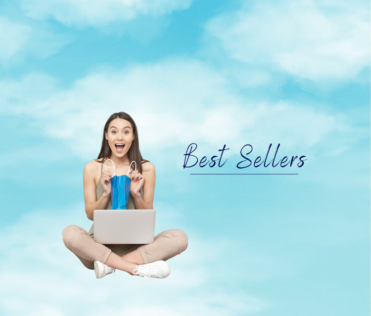 Blue sky and white clouds. Woman sat with a present in her lap and smiling on receipt of a gift. Text reads Best Sellers