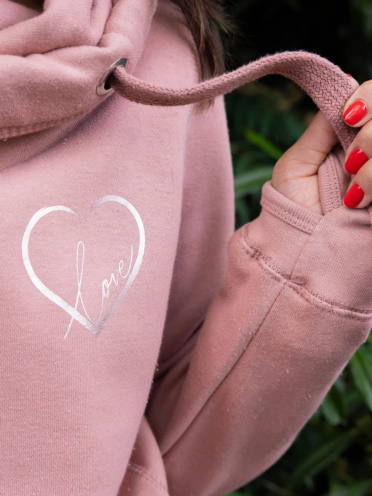 Close up of  Womens Cowl Neck Hoodie - Dusty Pink ladies hoodie with rose gold metallic love heart motif and the word love in script font inside. Long sleeves and thumb loops to cuffs. 
