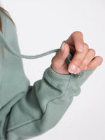 Dusty Green Cowl Neck Hoodie close up of thumb loops to sleeves and chunky drawstring. 