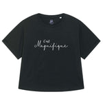 Black womens T-Shirt with dolman sleeve, rib neck collar and sleeve cuff fold. Oversized ladies t-shirt with a short sleeves, inspired by the 1990s fashion trend. White slogan script font design reads French phrase C'est Magnifique