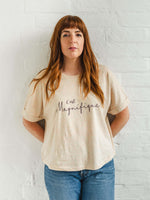 Ladies T-Shirt with dolman sleeve, rib neck collar and sleeve cuff fold. Rainbow Heather - light beige/cream base colour with multicolour flecks. Oversized women’s t-shirt with a short sleeves, inspired by the 1990s oversize trend.. Black slogan script font design reads French phrase C'est Magnifique