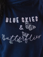 Close up of design on Womens Navy blue cross cowl neck hoodie. Four light grey butterflies and slogan Blue Skies and Butterflies to front. Unisex oversized fit. Light purple font with light grey back shadow. Long sleeves, metal toggle to drawstring