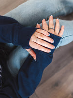 Close up of Womens Navy blue hoodie with cross cowl neck. Positive slogan and light grey butteflies design.  Unisex oversized hoodie. Long sleeves and thumb loops to cuffs 