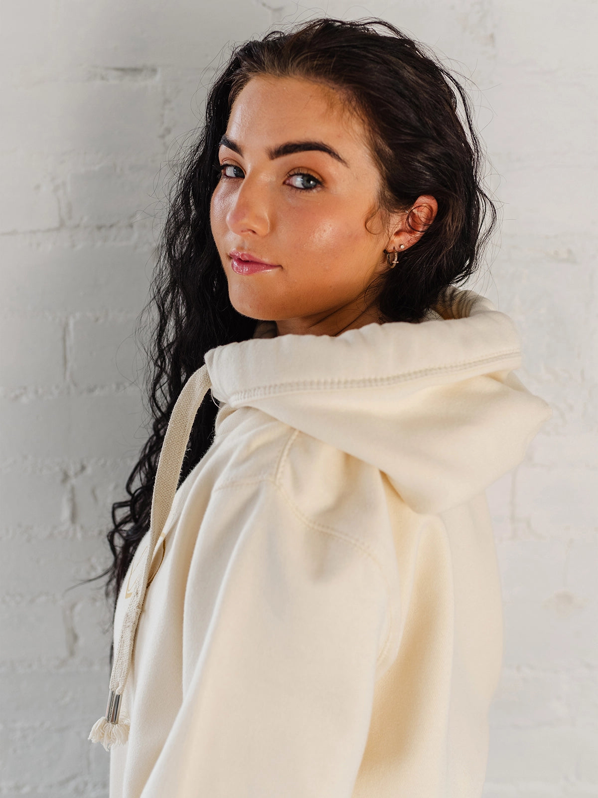 Ladies Cowl Neck Hoodie - Side view of Cotton Vanilla cream hoodie with hood, and long sleeves. Cross neck sweatshirt with hood and thick fabric drawstrings with metal toggle