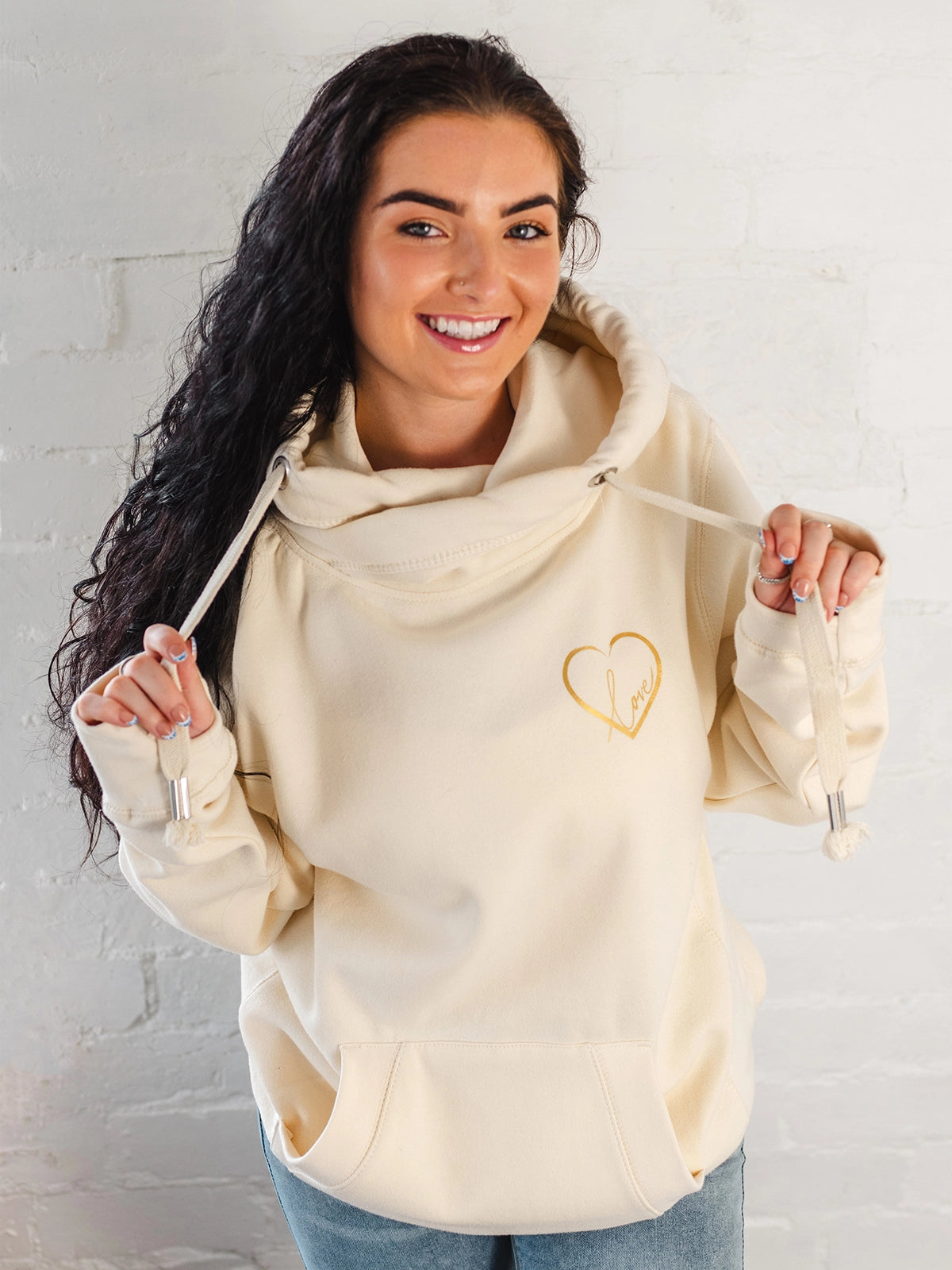 Womens Cowl Neck Hoodie - Cotton Vanilla cream hoodie with gold metallic love heart motif. Long sleeves and thumb loops to cuffs. Front kangaroo pouch pocket. Cross neck sweatshirt with hood with silver metal eyelets for thick fabric drawstrings and silver metallic toggle. Cosy casual wear autumn / winter ladies hoodie 