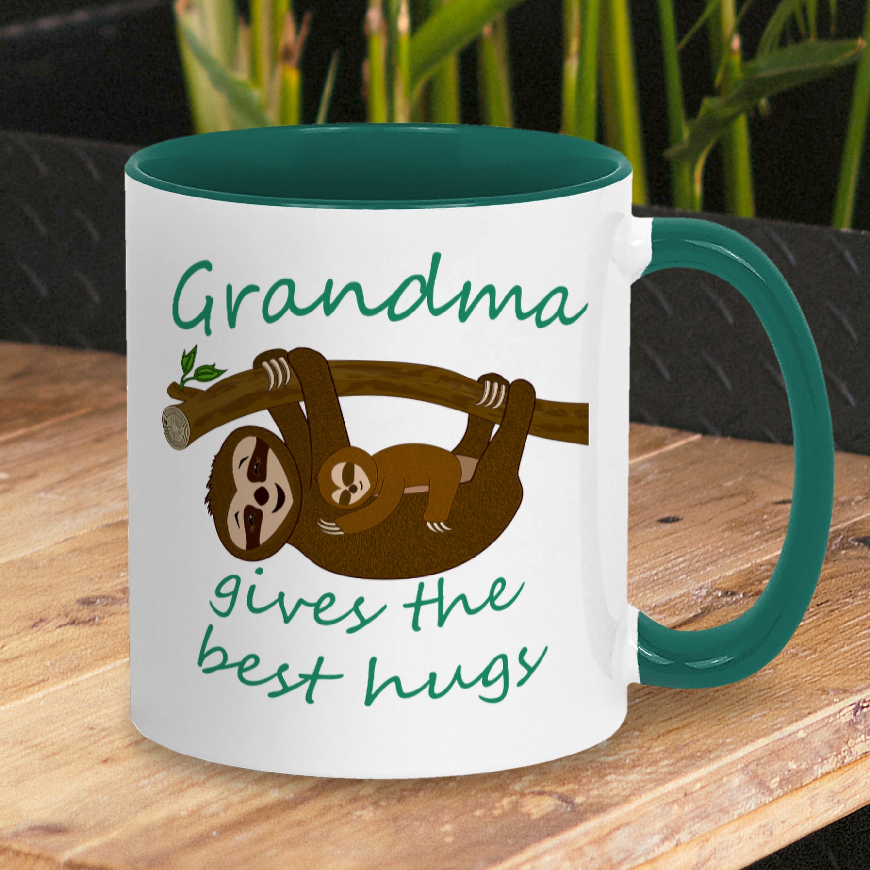 Personalised Tea / Coffee cup gift. Cute cuddly three toed sloths on a branch. Mum and baby. Two tone white with green ceramic coffee mug. Customisable name reads Grandma gives the best hugs in green font.
