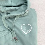 Close up photo of relaxed fit mid green hoodie with thumb holes to long sleeve arm cuffs