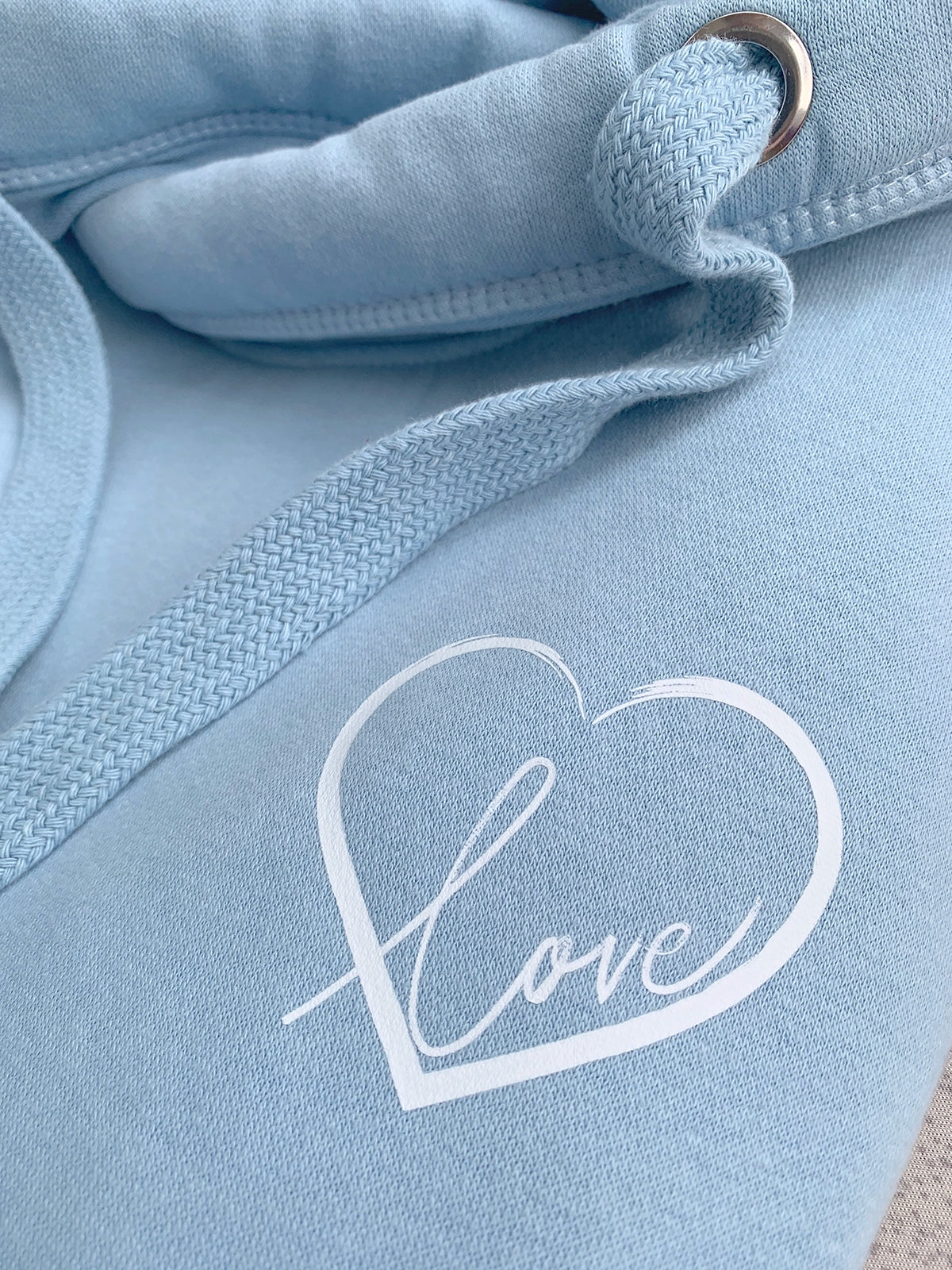 Light blue hoodie with a white heart-shaped 'love' design on the chest.