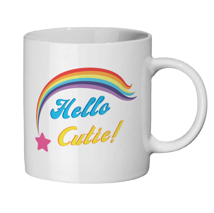 White tea / coffee mug with cute pink shooting star and rainbow trail about the words Hello Cutie blue 'Hello' and yellow 'Cutie'  slogan wording. White background 