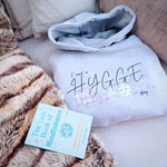 Hygge inspiration. Oversized grey womens hoodie with slogan I need a hygge day. Hygge home with book and fleece.