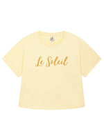 Butter yellow oversized t-shirt with loose short sleeves and rolled cuff. Round neck. Ladies summer t shirt  slogan design Le Soleil in matt metallic gold script font.  Organic Cotton summer top