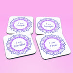 Wellbeing gift. Four square wooden backed personal affirmations coaster set. Theme is Letting Go in this set of four. Mandala design with daily affirmation wording inside the mandala.  Affirmations read I am Loved, I am Enough, I am Peaceful, I am Free (all coaster mandalas are a two-tone purple mandala),