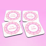 Wellbeing gift. Four square wooden backed personal affirmations coaster set. Theme is Letting Go in this set of four. Mandala design with daily affirmation wording inside the mandala.  Affirmations read I am Loved, I am Enough, I am Peaceful, I am Free (all coaster mandalas are a red and pink mandala),