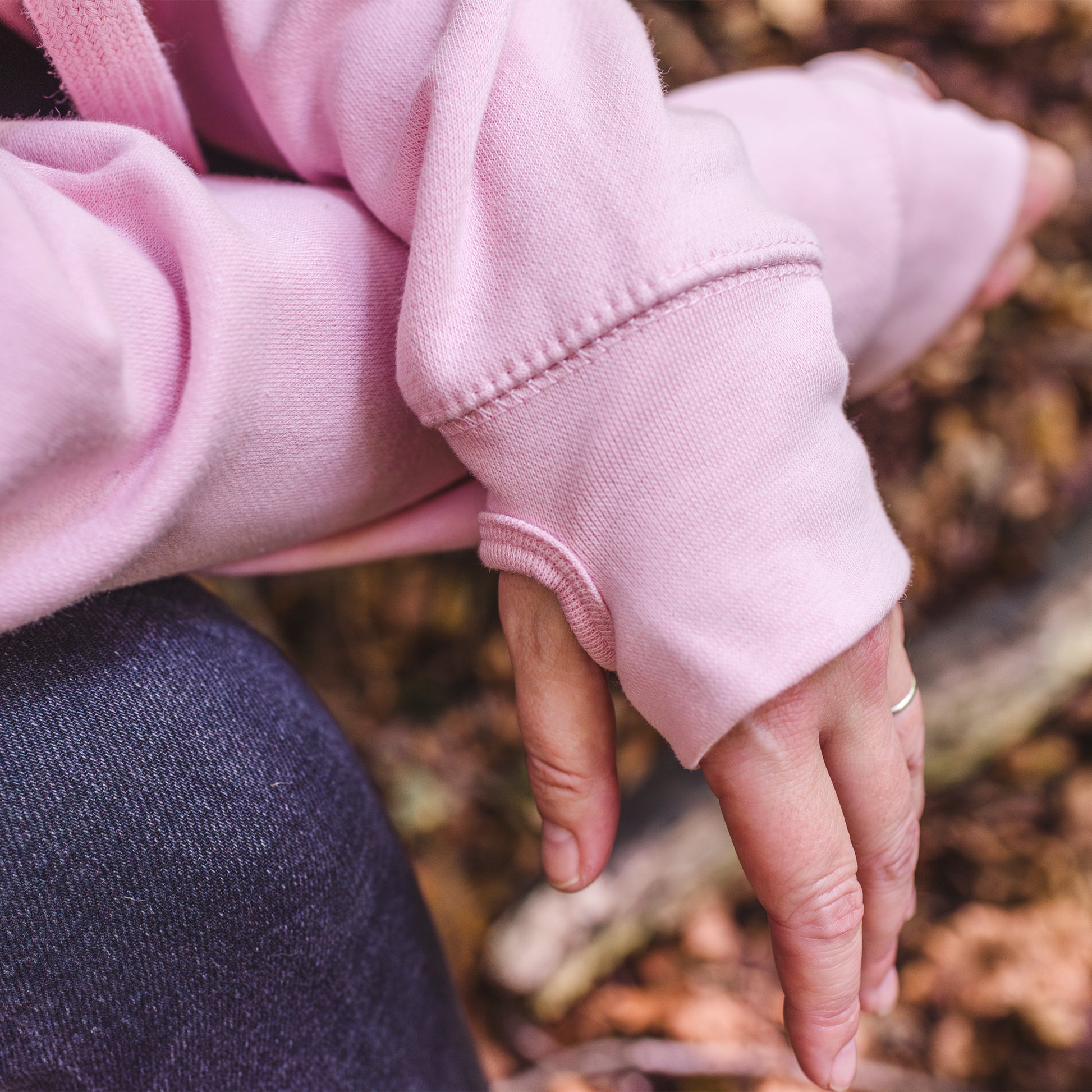 Close up of thumb loops of ladies fashion hoodie. baby pink womens hoodie Love heart cross cowl neck casual fashion hoodie. Cotton Polyester blend relaxed fit unisex oversized style hoodie design has love heart. Whitert to upper left of the chest with word Love in 