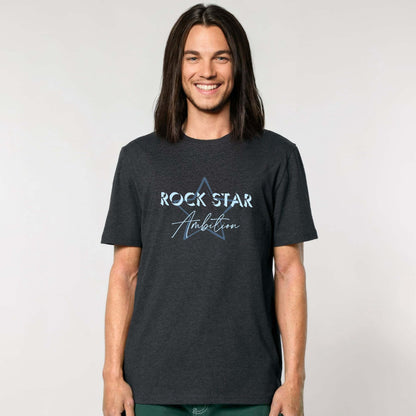 Organic cotton short sleeve t shirt. Man wearing men's dark heather grey short sleeve graphic tshirt. Crew neck casual wear. Band Tee Design is teal blue star outline behind wording "ROCK STAR" in upper case shadowed  light blue text, then "Ambition" below in script. Casual unisex top