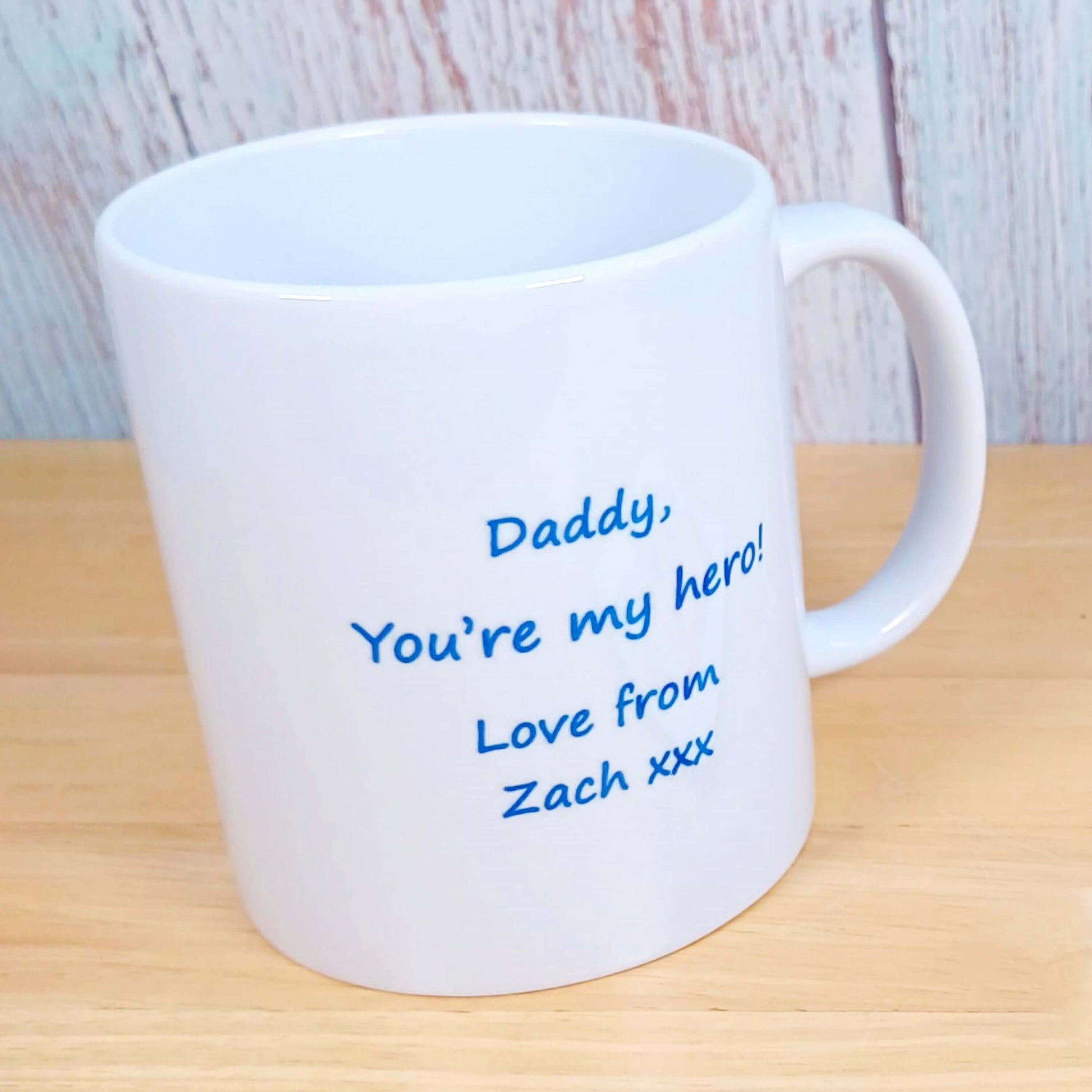 Birthday or Father's Day Gifts for Dad - Personalised message on reverse side of mug shown in this image. Reverse side has SuperDad themed design. White ceramic coffee mug with red and yellow Superman Logo design and blue wording " Dad " intertwined under