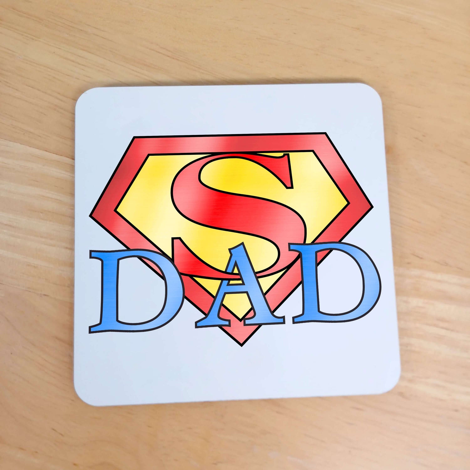 Birthday or Father's Day Gift for Dad - Superhero themed coaster. White wooden coaster with red and yellow Superman Logo design with blue wording " Dad " intertwined underneath