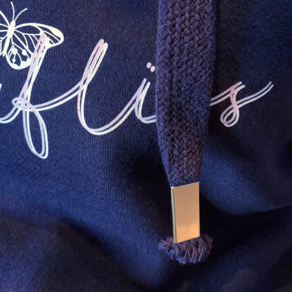Navy blue cotton and polyester oversized relaxed fit hoodie Shows close up to drawstring with metal toggle at the end Can also see part of the grey butterfly design and slogan wording  in a lilac and showed grey handwriting font