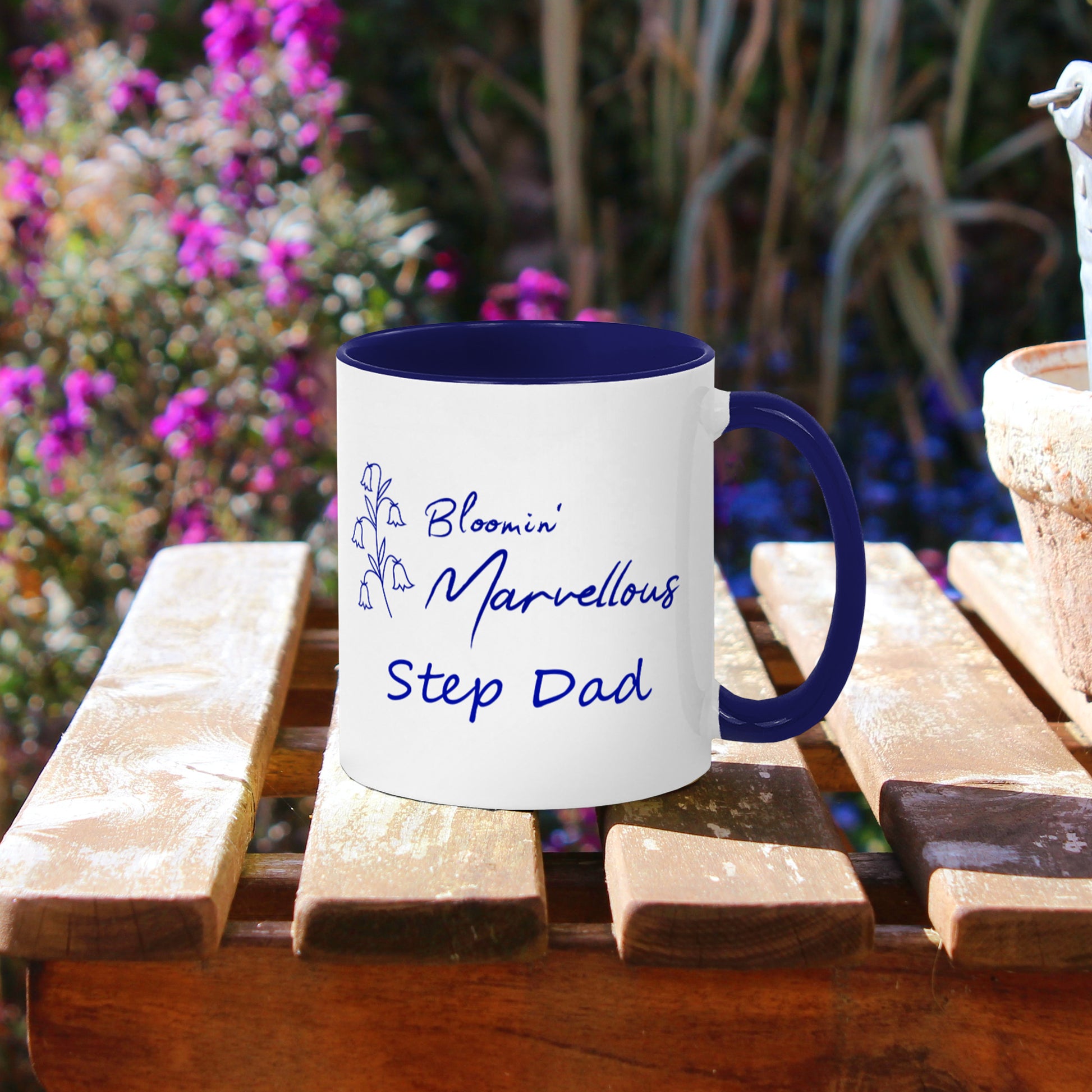 Garden  plant theme mug. Personalised name, White ceramic 11oz coffee cup with navy blue handle and inner. Floral design navy blue bluebells outline and wording Bloomin Marvellous in script style font next to flowers. Personalisation Step Dad below.